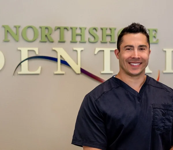 Dr. Jeffrey M. Hepburn, DDS, in front of the Northshore Dental sign.